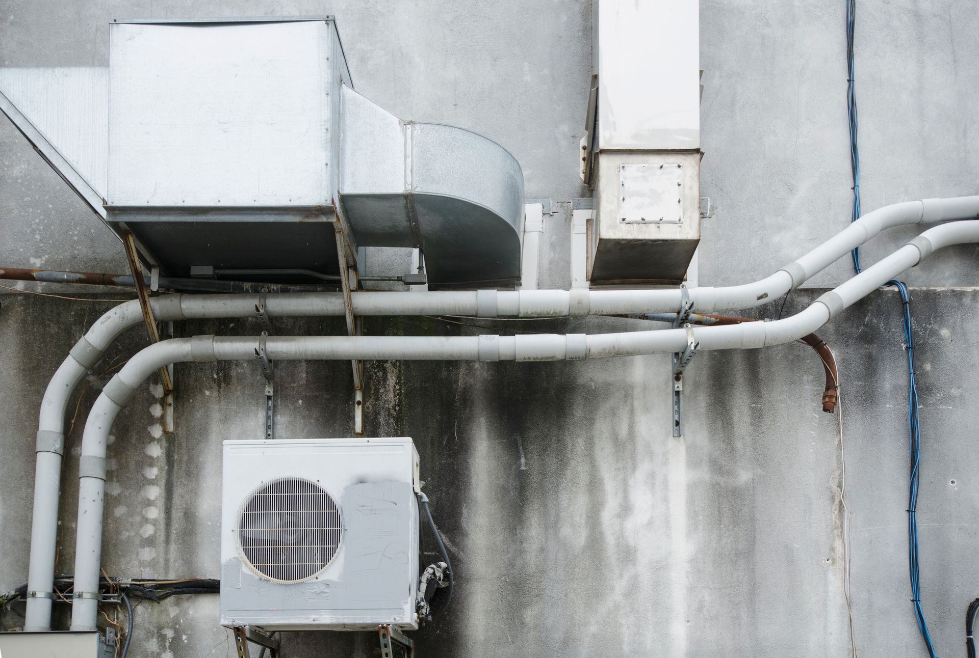 There are a lot of pipes hanging from the side of a building - Concord, NC - Concord Heating & Air conditioning
