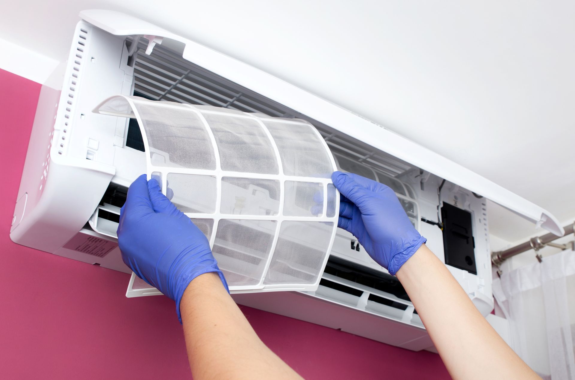 A person wearing blue gloves is cleaning an air conditioner - Concord, NC - Concord Heating & Air conditioning