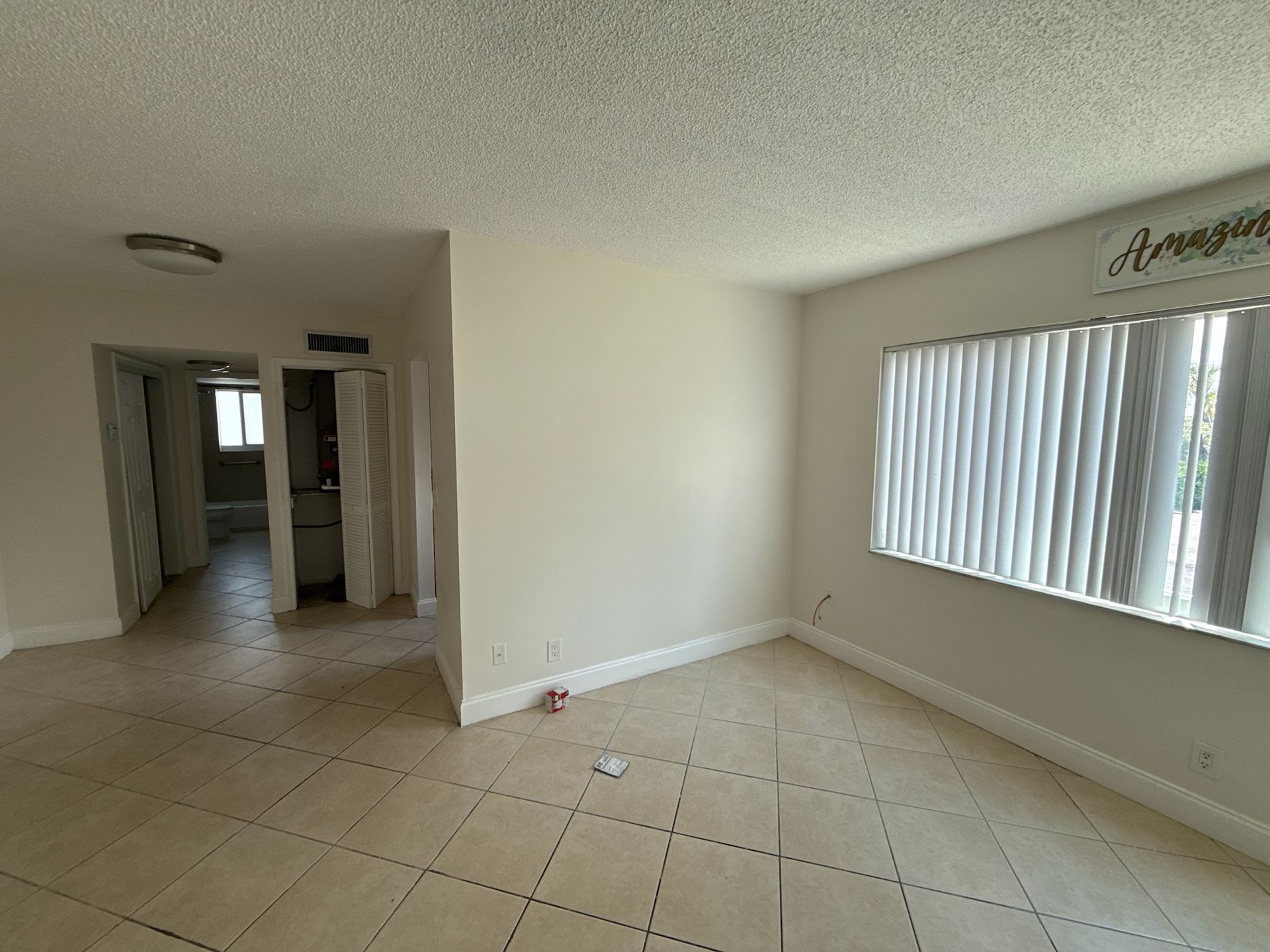 Photo of a living room with a long window and the hallway in the background