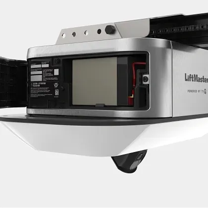 A LiftMaster garage door opener with its battery backup compartment open, showing the internal battery pack.