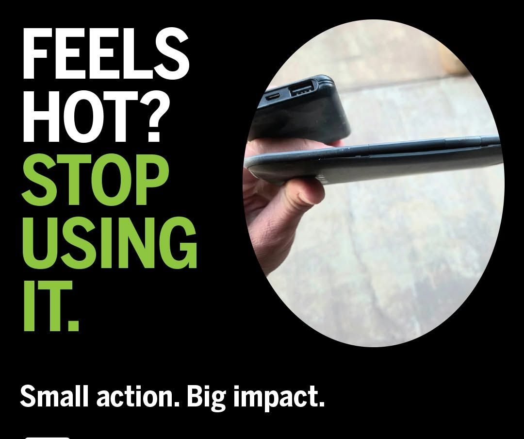 Close-up of a split cell phone held near a surface with text: “Feels hot? Stop using it.”