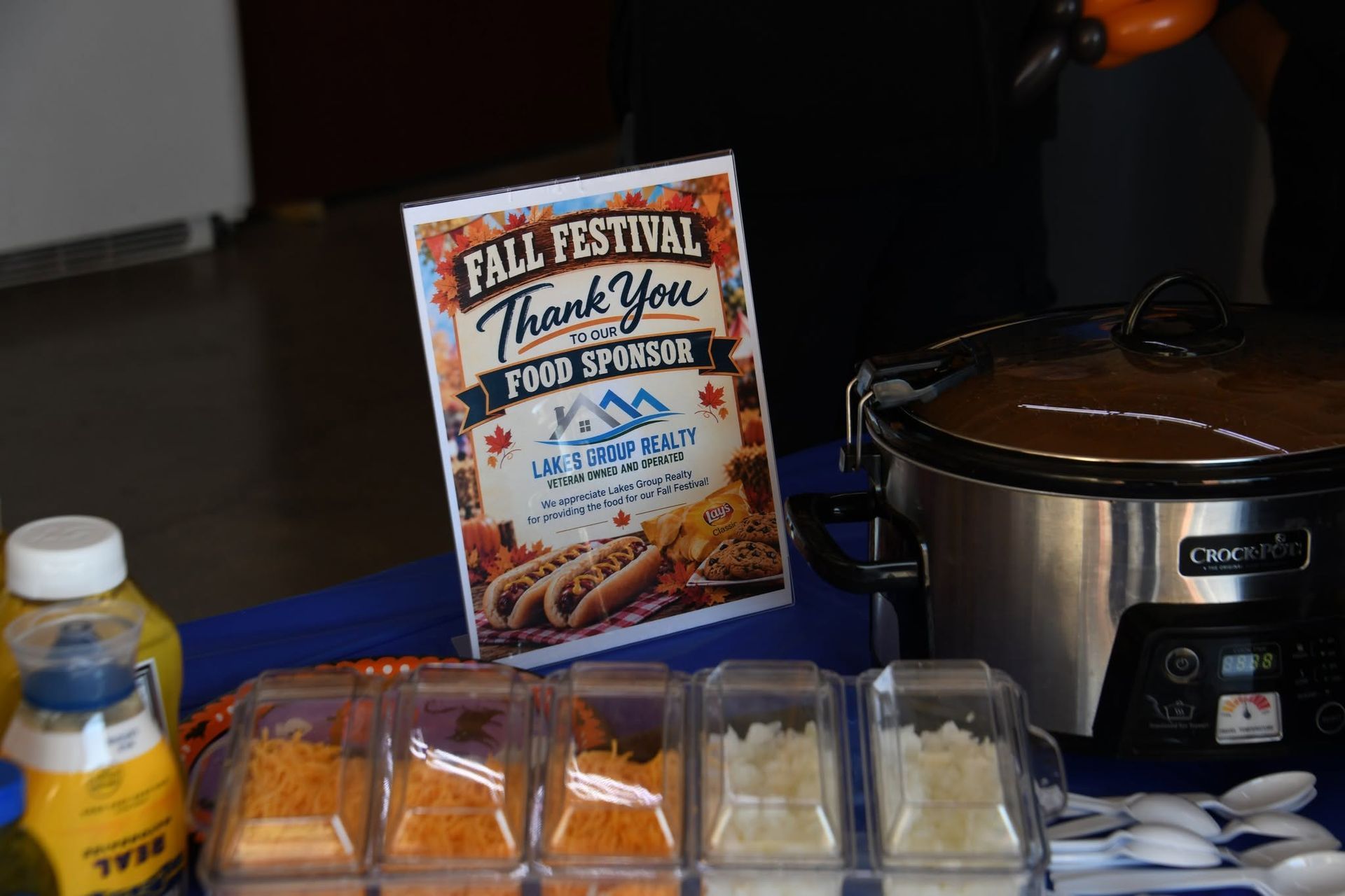 Food festival display with boxed pastries, a slow cooker, and utensils on a table