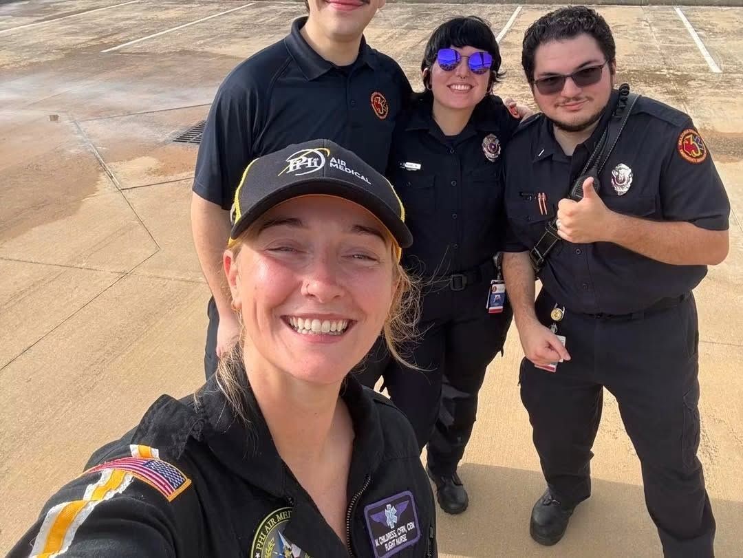 Four uniformed emergency responders smiling for a group selfie.