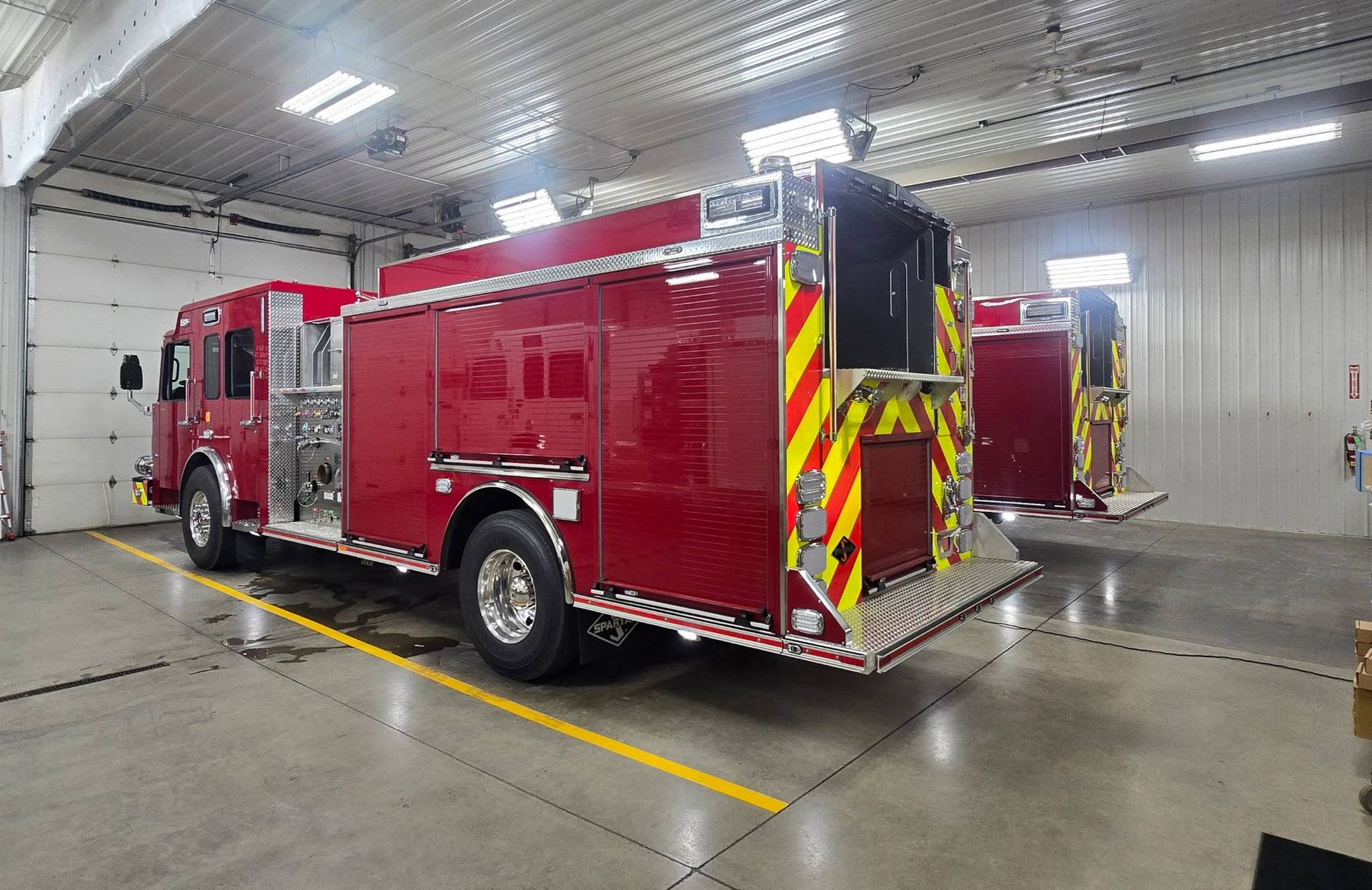 2 red fire engines in a garage