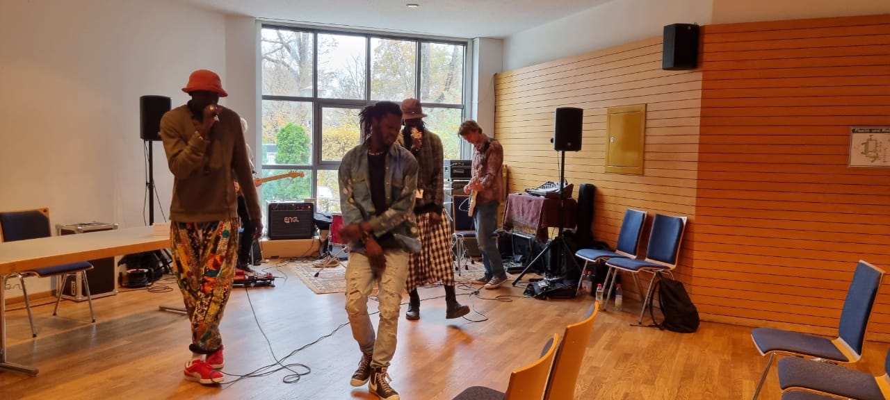A group of people are standing in a room playing instruments.