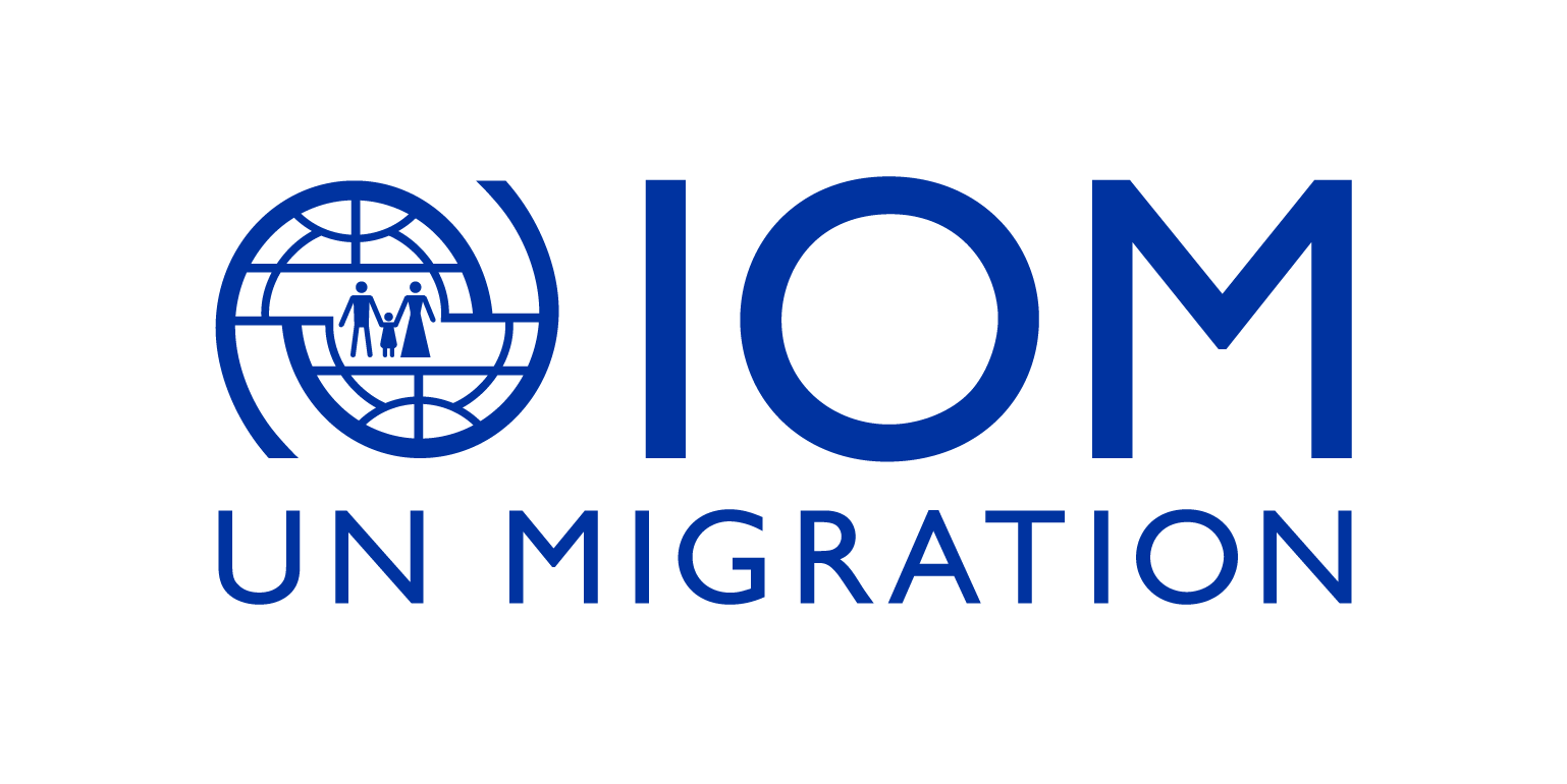 Ein blaues Logo für IOM UN-Migration mit einem Globus und Menschen darauf.