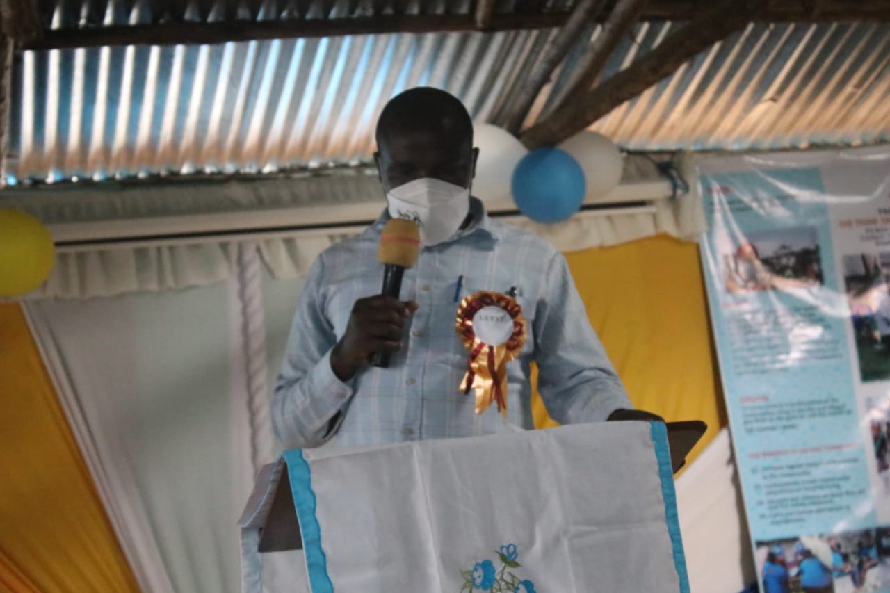 A man wearing a mask is giving a speech at a podium