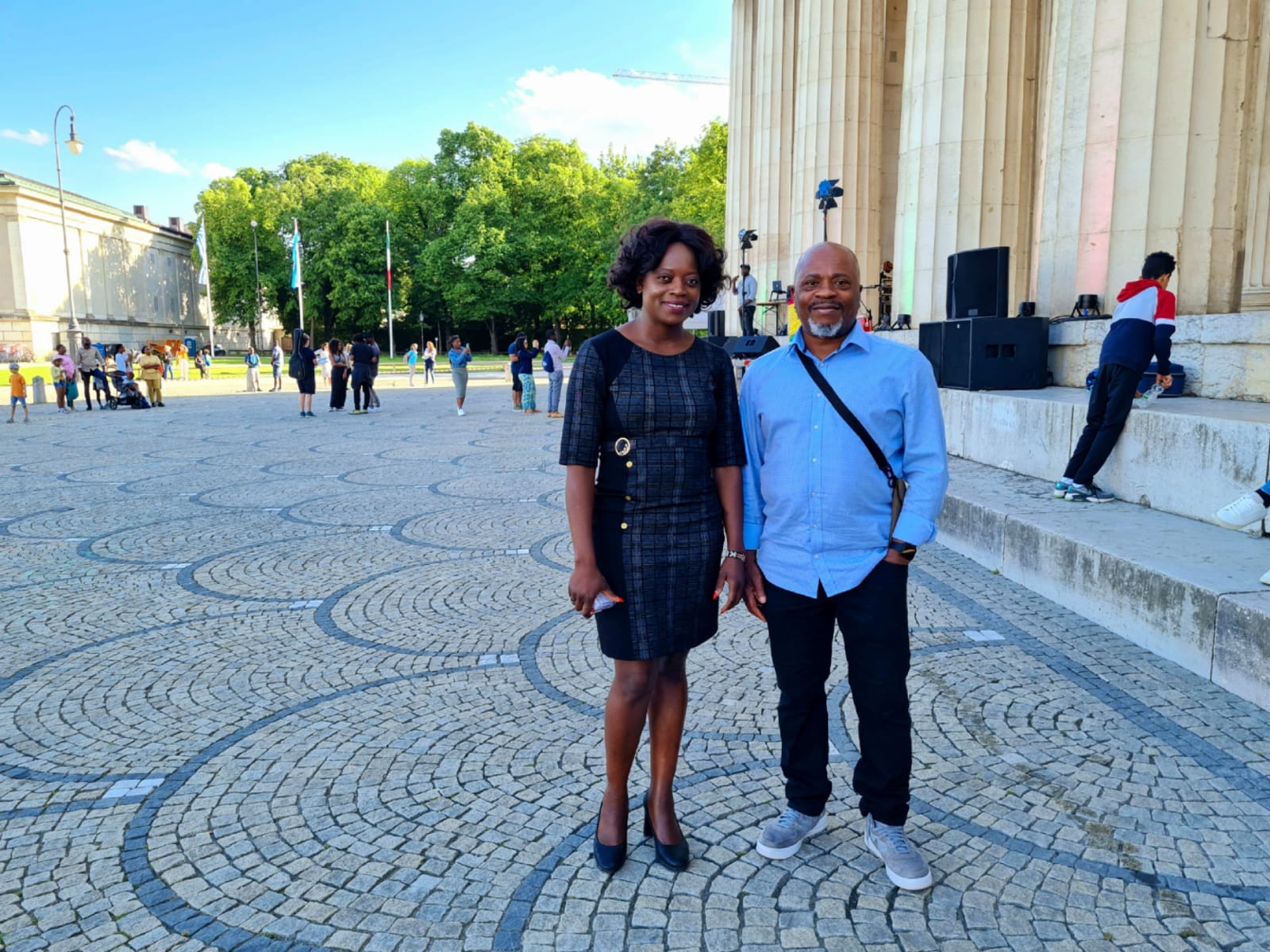 A man and a woman are standing next to each other on a cobblestone street.