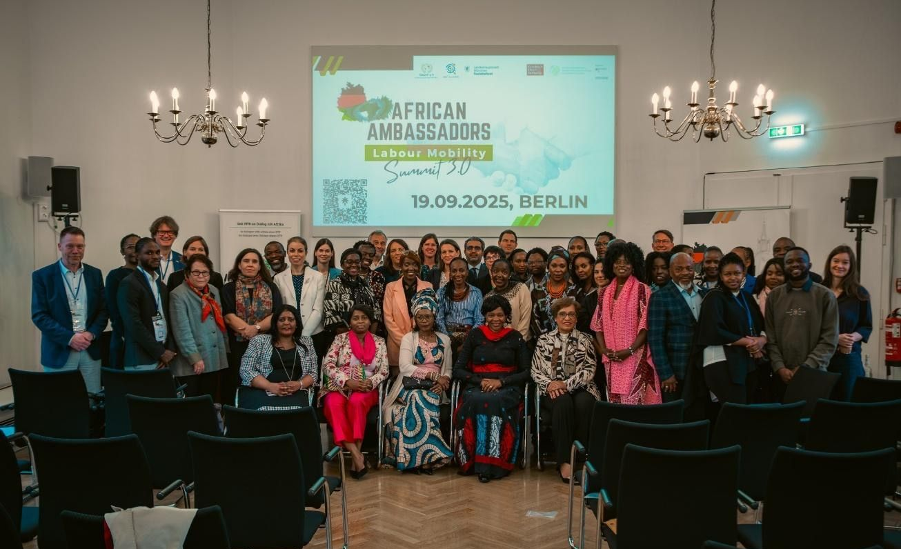 Group photo of African Ambassadors at a Berlin summit. Attendees stand in a conference room.