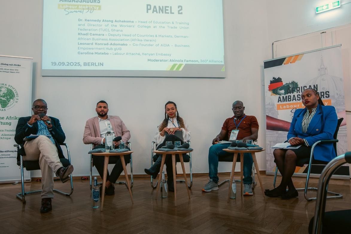 Panel discussion with five people seated at a table, facing the audience.