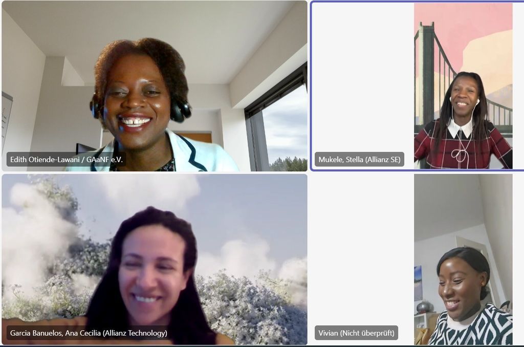 Four people on a video call, smiling and looking at the camera.