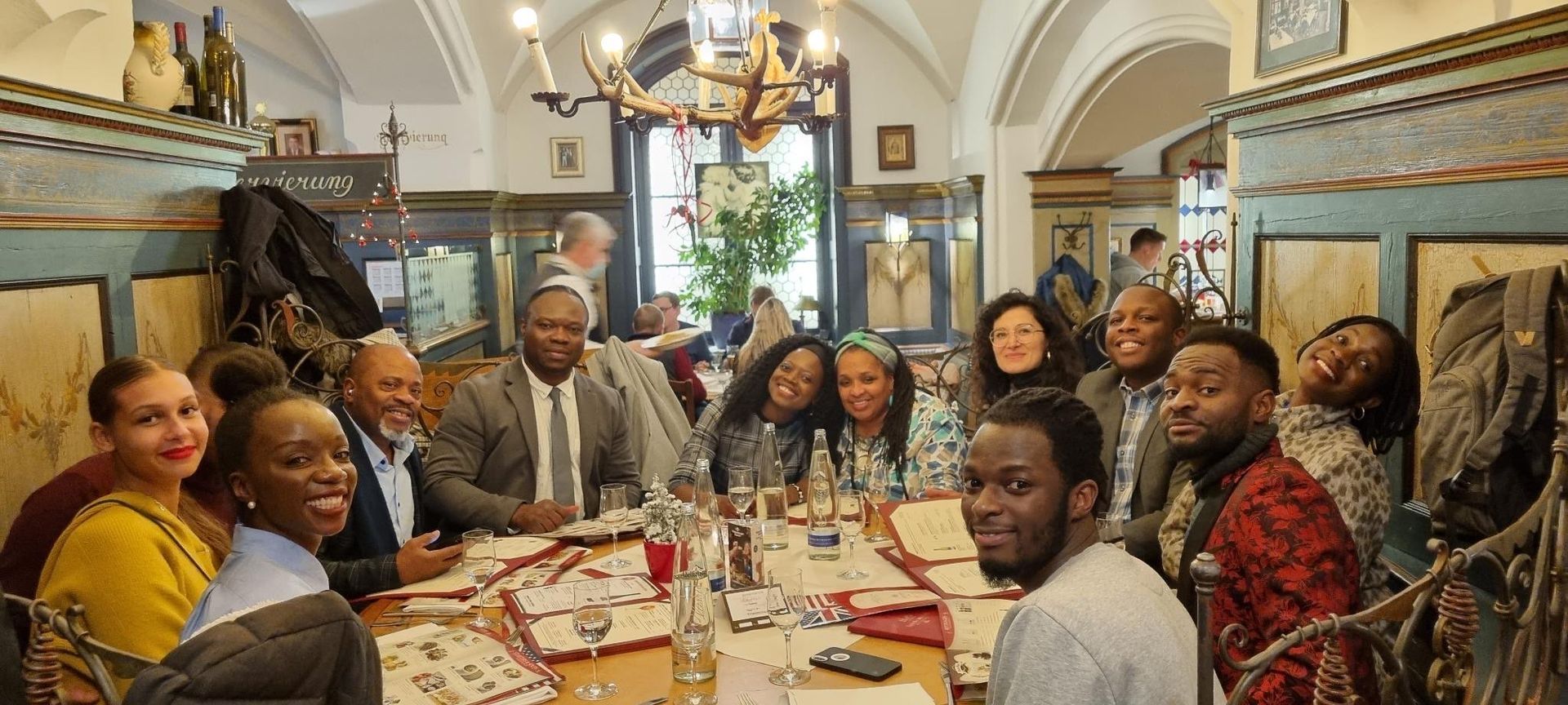 A group of people are sitting at a long table in a restaurant.