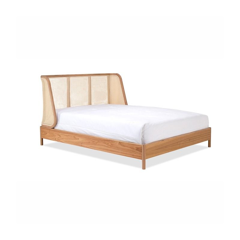 Estrutura de cama de madeira com cabeceira de palhinha, roupa de cama branca.
