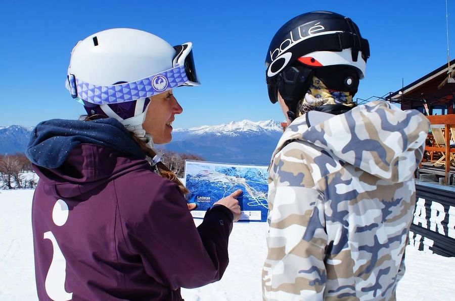 Dos personas están paradas en la nieve mirando un mapa.