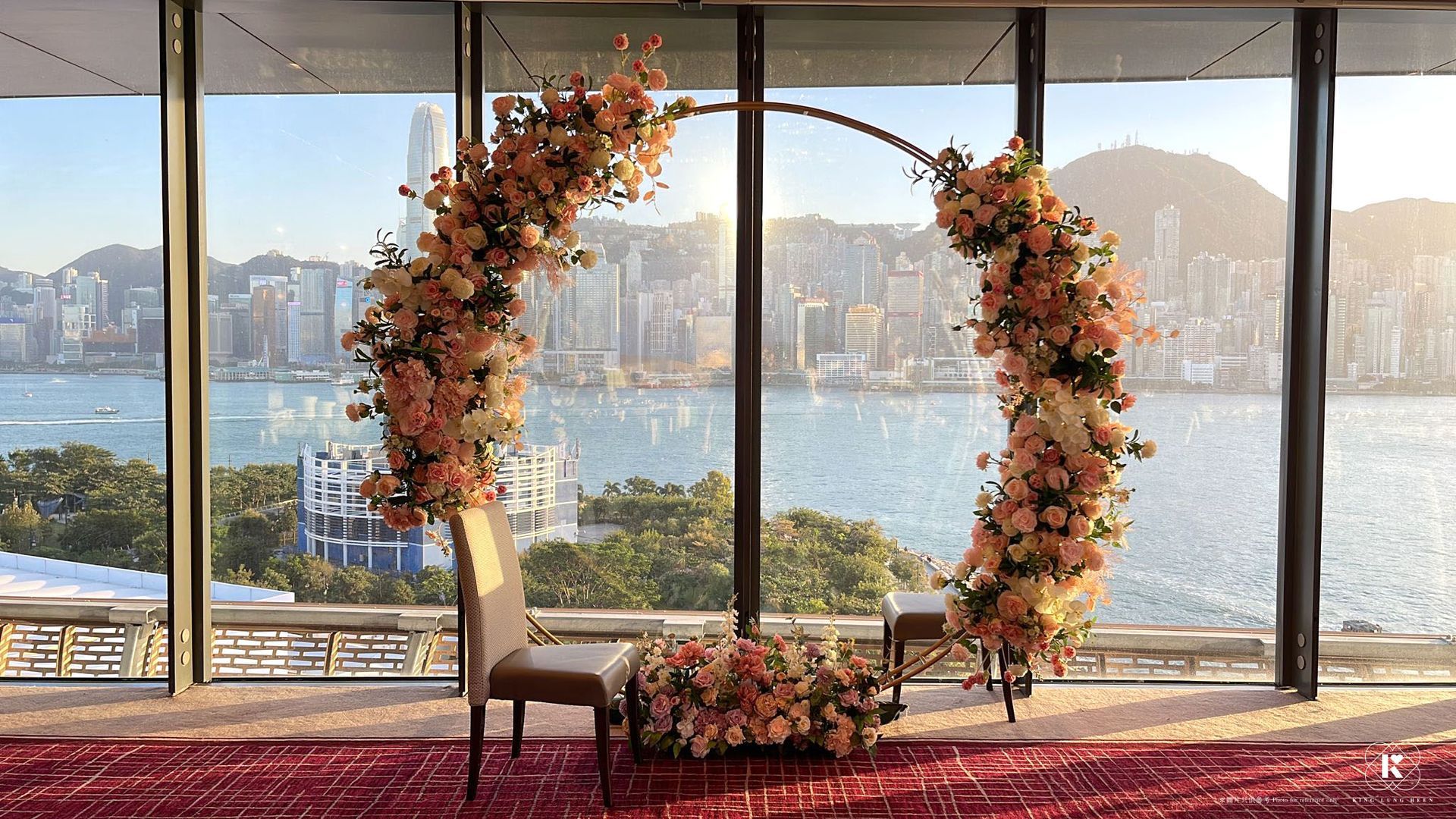 Floral archway decorated with peach flowers, set against a cityscape backdrop.