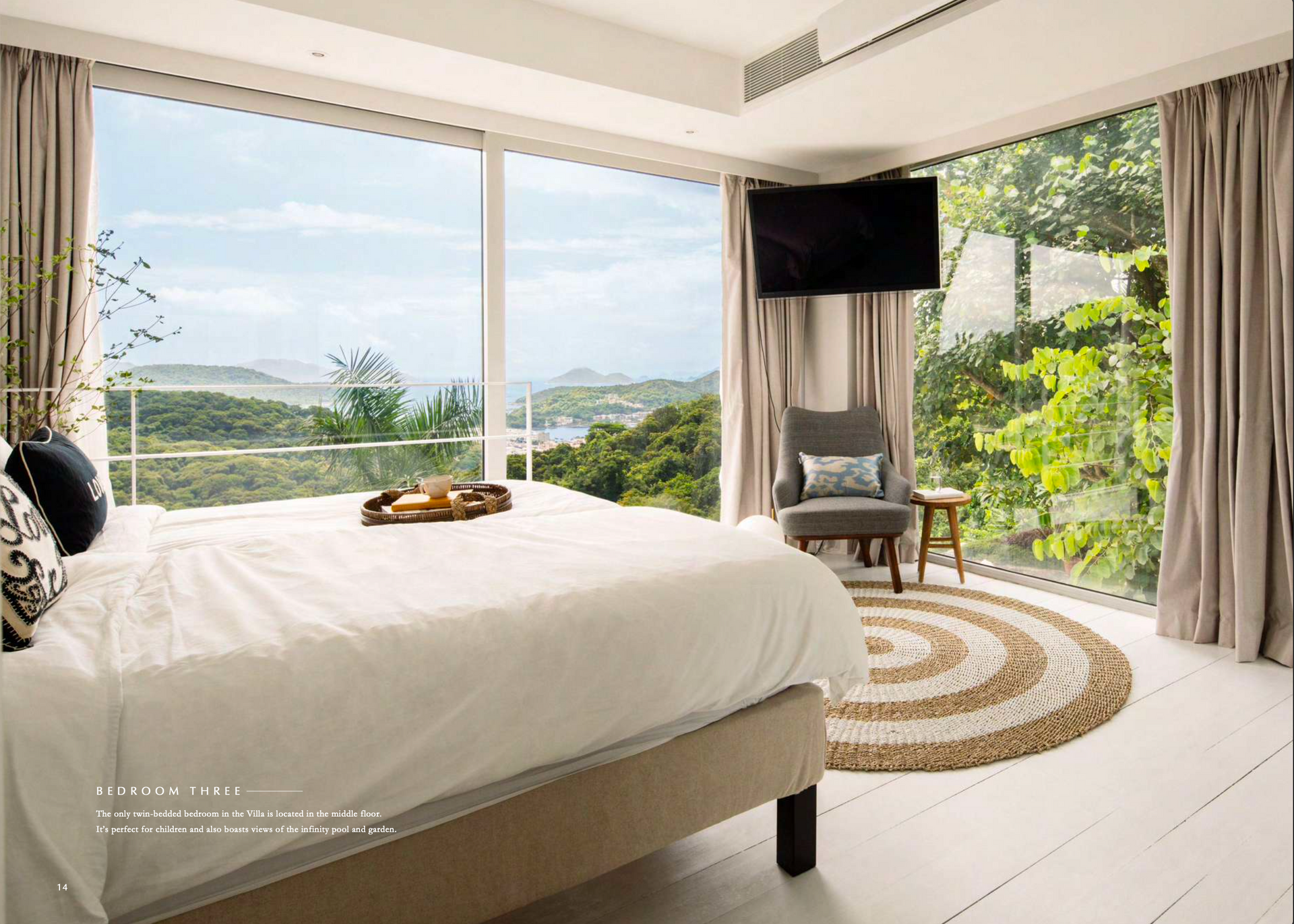 Bedroom with bed, scenic window view, chair, and round rug.