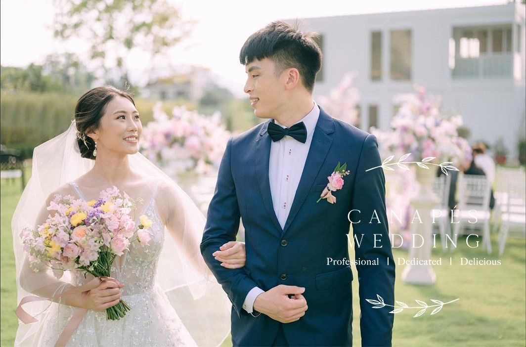 Bride and groom holding hands, smiling, walking outdoors during wedding ceremony.