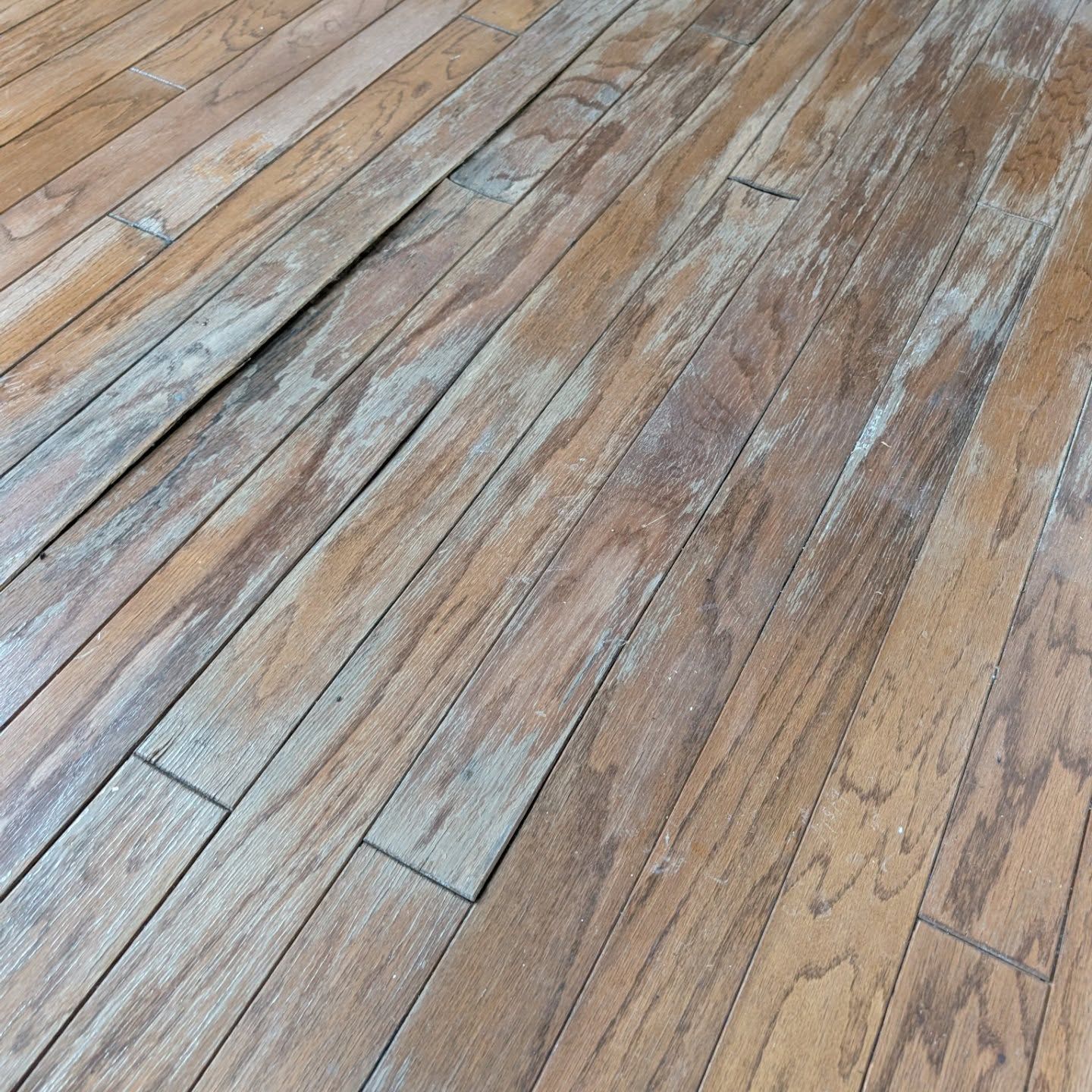 Weathered wooden floorboards with gray and tan planks arranged diagonally