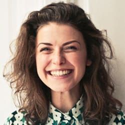 Femme souriante aux cheveux bouclés sur fond clair
