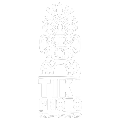 Logo de totem tiki en dessin au trait blanc avec un motif d'appareil photo et le texte « TIKI PHOTO » en dessous.