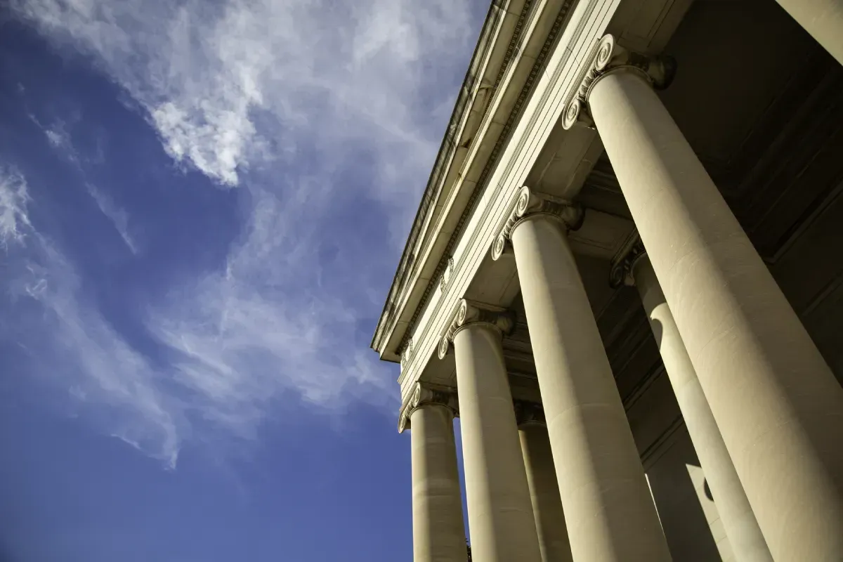 Colonnes d’un édifice classique sur fond de ciel bleu nuageux