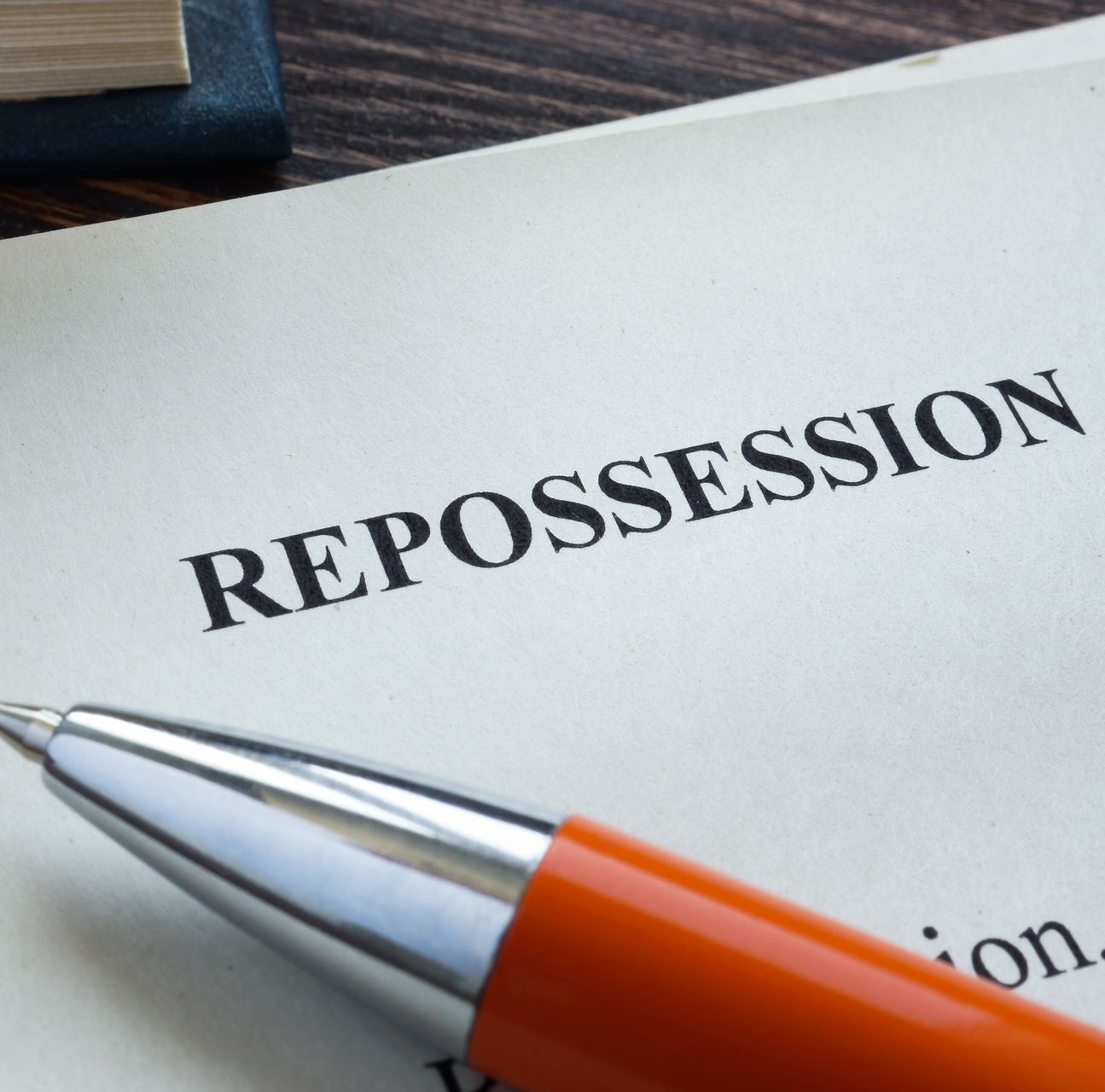 A pen rests on a piece of paper that says repossession