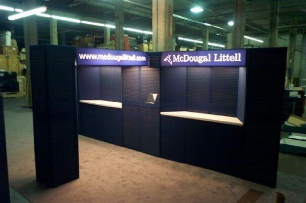 Dark blue McDougal Littell booth with website address, display shelves, and recessed lighting.
