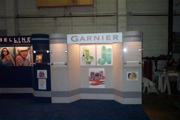 Garnier product display at an event. Light and dark panels with product visuals and logo.