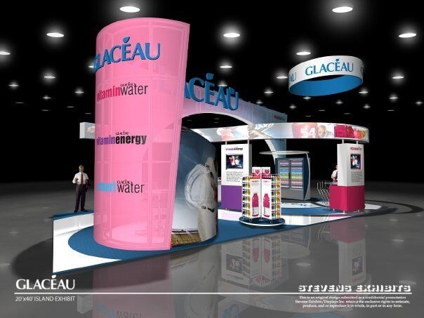 Glacéau Vitaminwater booth at a trade show with pink and blue branding. Includes product display and people.
