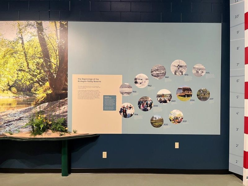 Wall display with timeline of circular images and text next to a nature photo.
