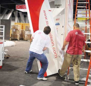 Two people moving a white and red panel with Two people moving a white and red panel with