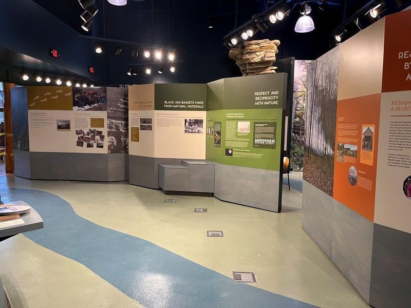 Museum exhibit with informational panels and blue flooring depicting a river.