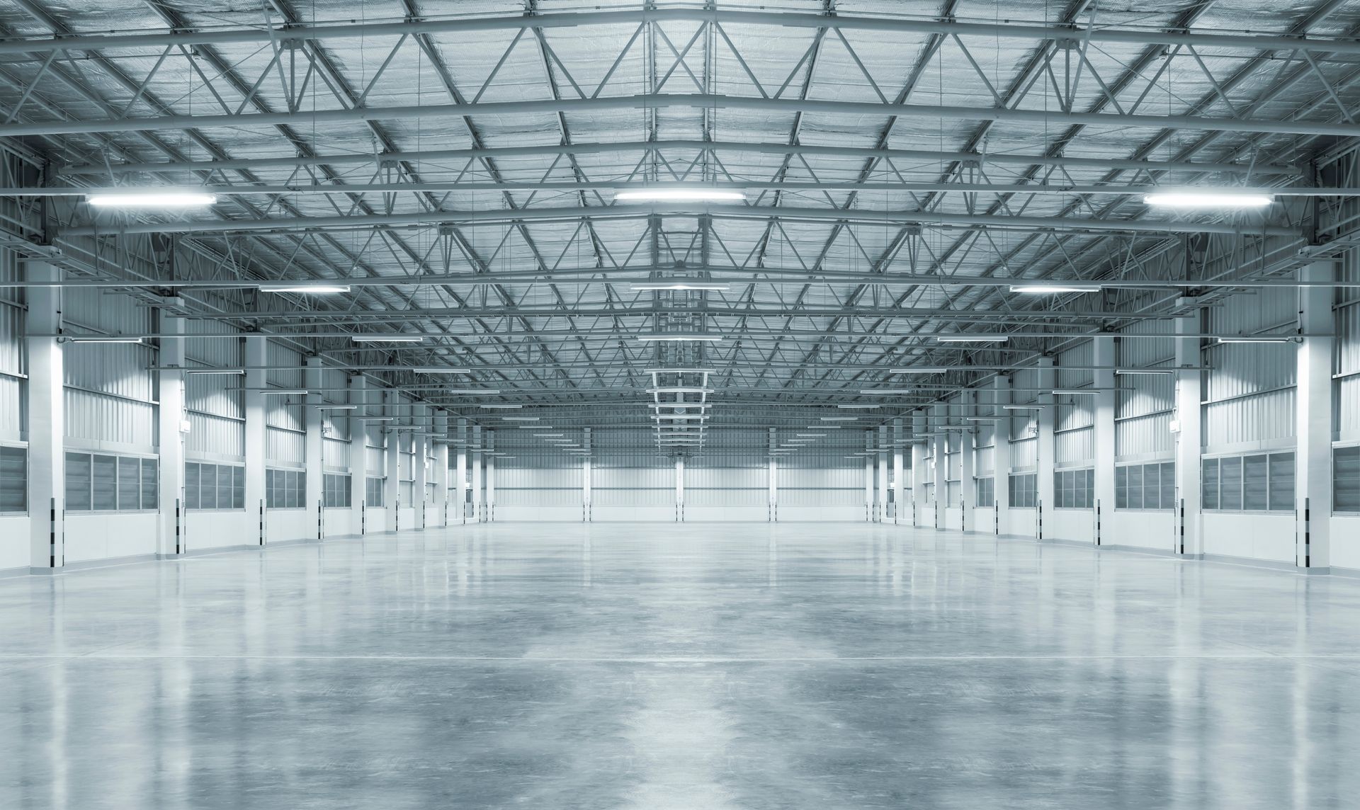 Empty industrial warehouse with a high metal ceiling and polished concrete floor
