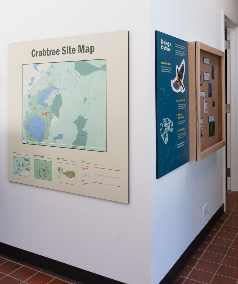 Wall-mounted Crabtree Site Map and Biological Studies display in a hallway. Beige and teal colored panels.