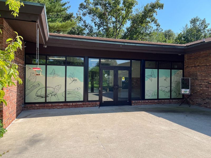 Brick building exterior with large windows, decorative window film, and a double-door entrance.