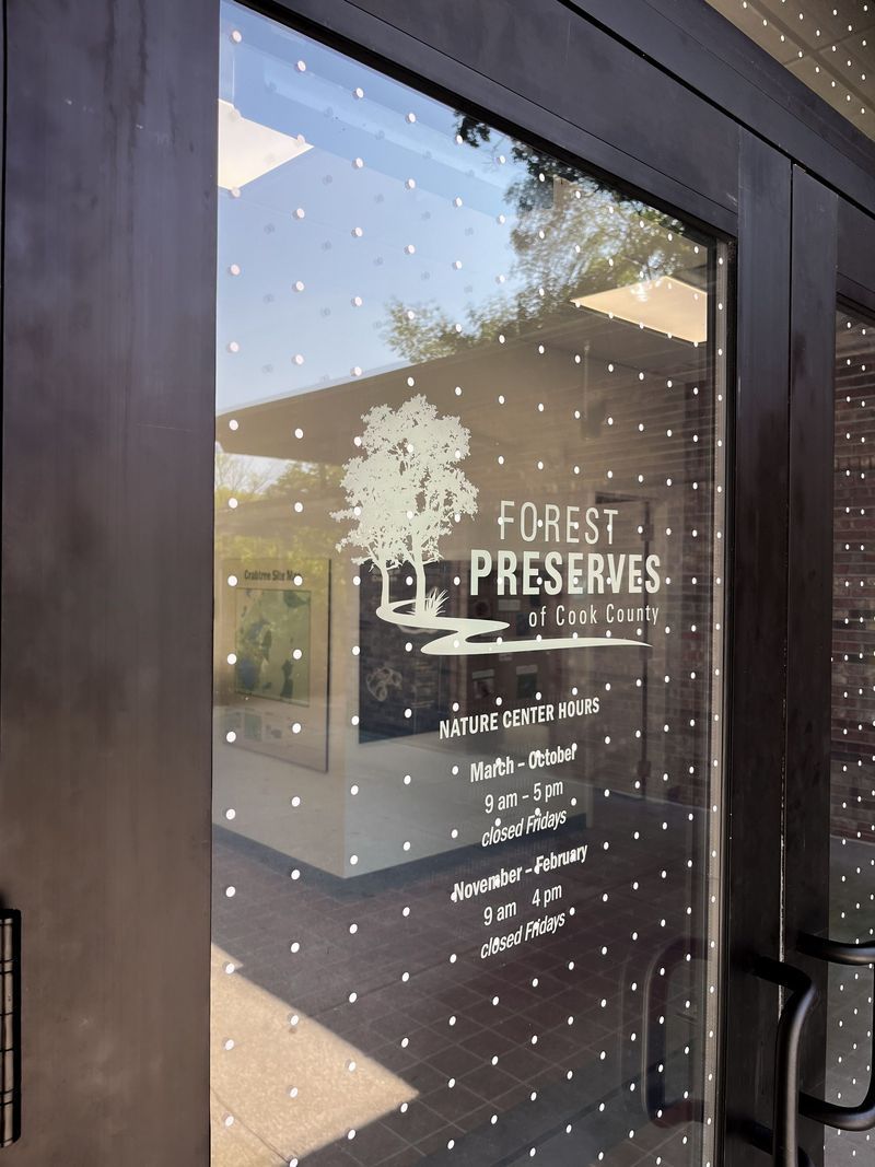 A glass door with the Forest Preserve's logo. White dots decorate the glass.