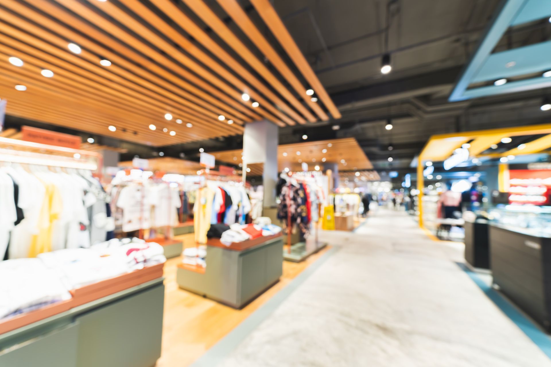 Clothing store interior with racks of clothes and shoppers.