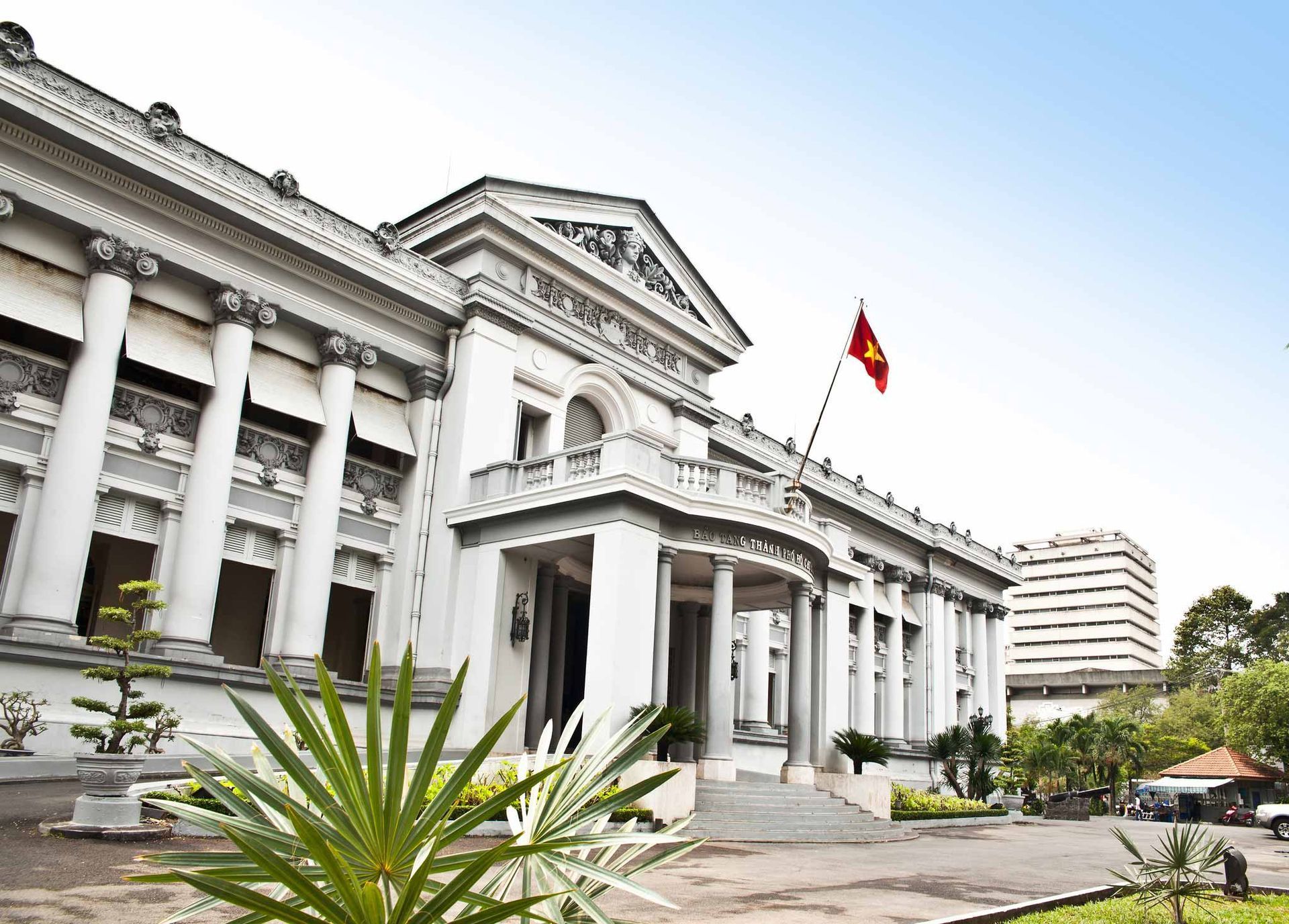 White neoclassical museum building with Vietnamese flag. White neoclassical museum building with Vietnamese flag.