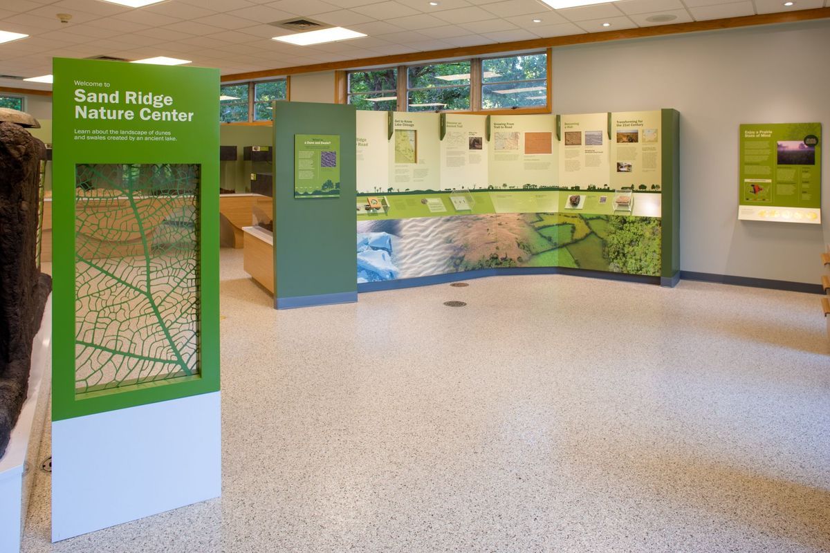 Sand Ridge Nature Center exhibit hall with informational displays and leaf graphic sign.