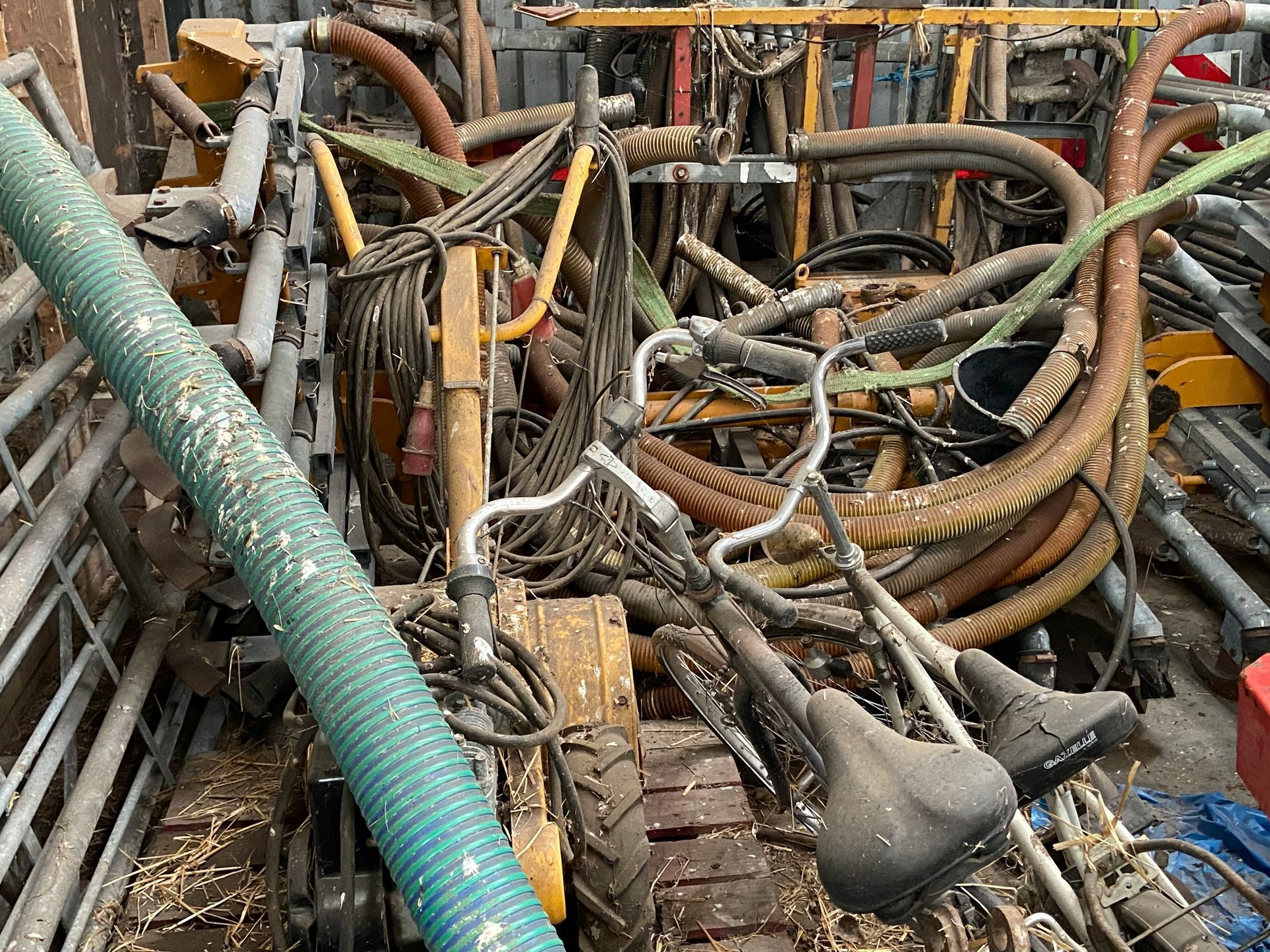 A pile of old bicycles , hose , and other items.