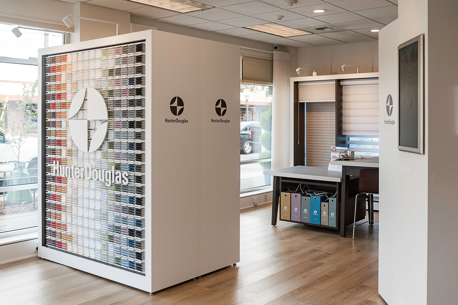Modern office interior with desks, glass partition, and shelving in a bright open workspace