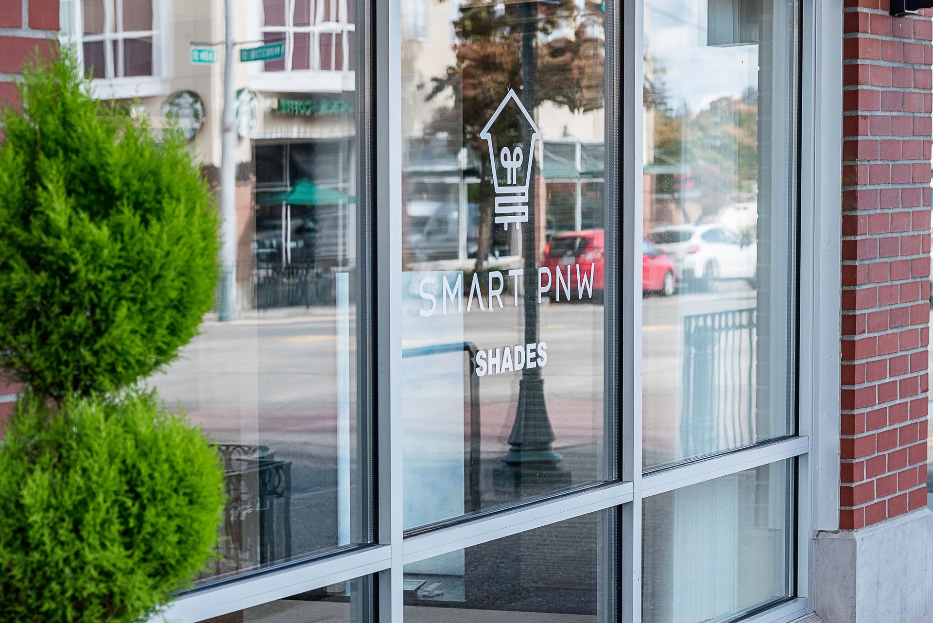 Storefront window with reflection and a red-brick wall beside it