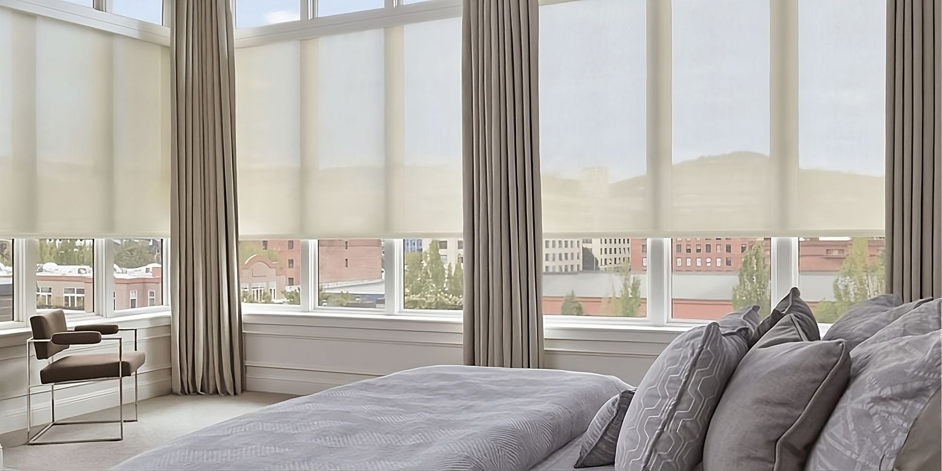 Functional and modern Hunter Douglas Designer Solar Shades on expansive windows in a stylish bedroom
