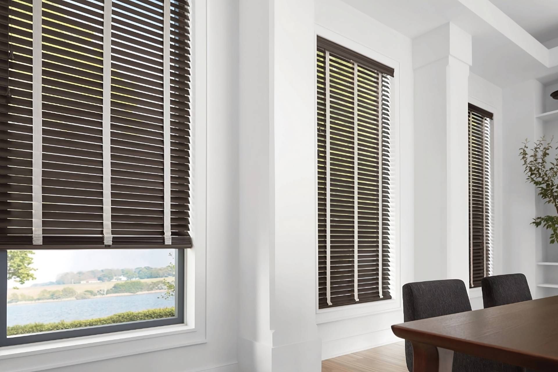 Hunter Douglas wood blinds with decorative tape on tall windows in a dining room