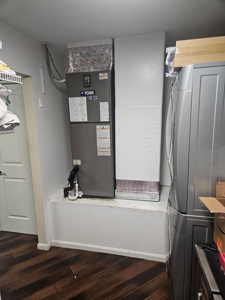 Kitchen with a recessed refrigerator alcove, gray walls, white trim, and dark wood flooring.
