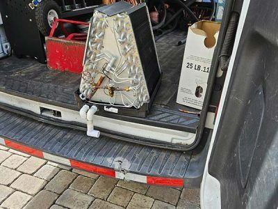 Portable generator and gear in the open back of a vehicle on a cobblestone street