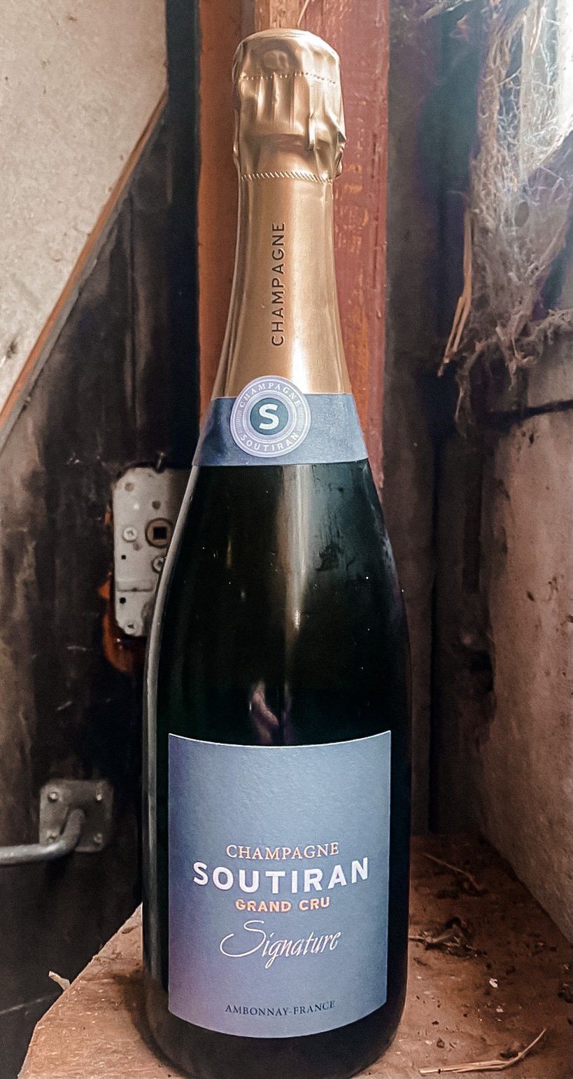 Fles mousserende wijn, donkerblauw etiket met de naam 