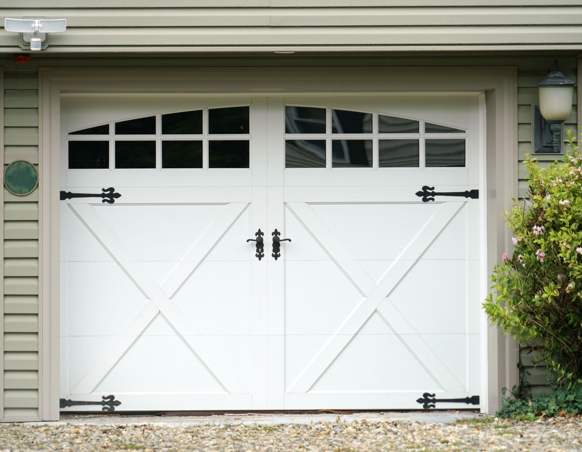 White double garage doors with black hardware and window panes. White double garage doors with black hardware and window panes.