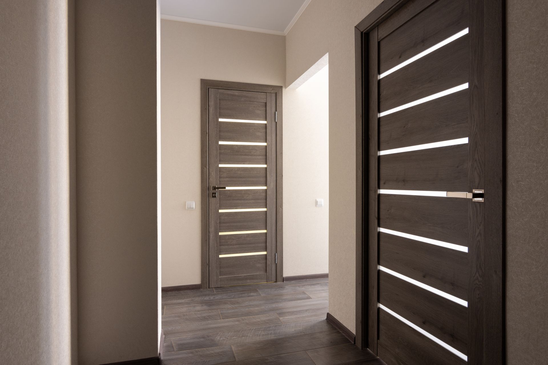 Modern hallway with dark wood interior doors featuring horizontal frosted glass panels.