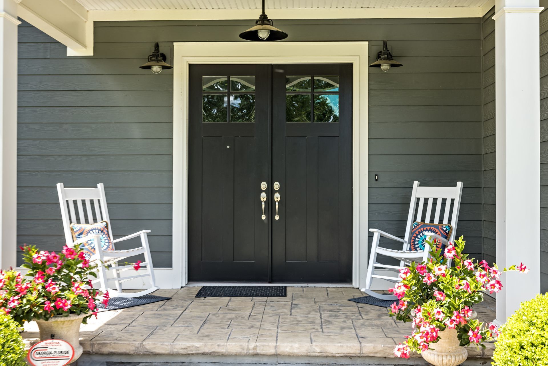 Close-up of a modern window handle and lock on a residential window frame. a house entrance featuring double black doors with glass panes at the top